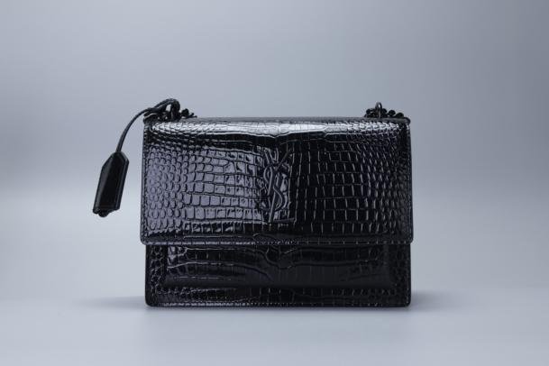 Bolsa compacta preta com textura marcada e alça curta